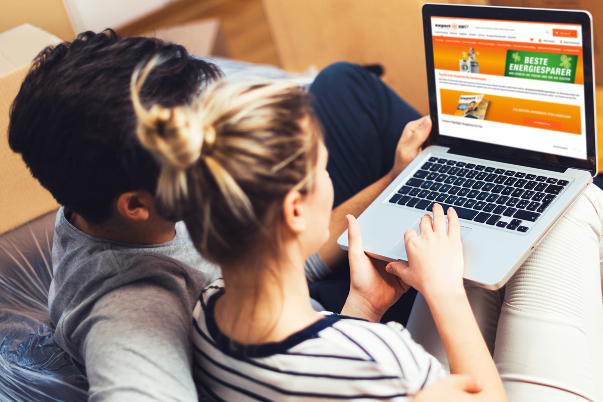 paar schaut auf dem Laptop den expert onlineshop an